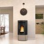 Poêle à granulés Noris 12 kW pour chauffage performant dans un intérieur moderne avec horloge murale décorative.