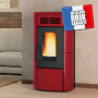 Poêle à granulés rouge Terry Plus 12 kW chauffant un salon moderne, idéal pour un chauffage écologique et efficace.