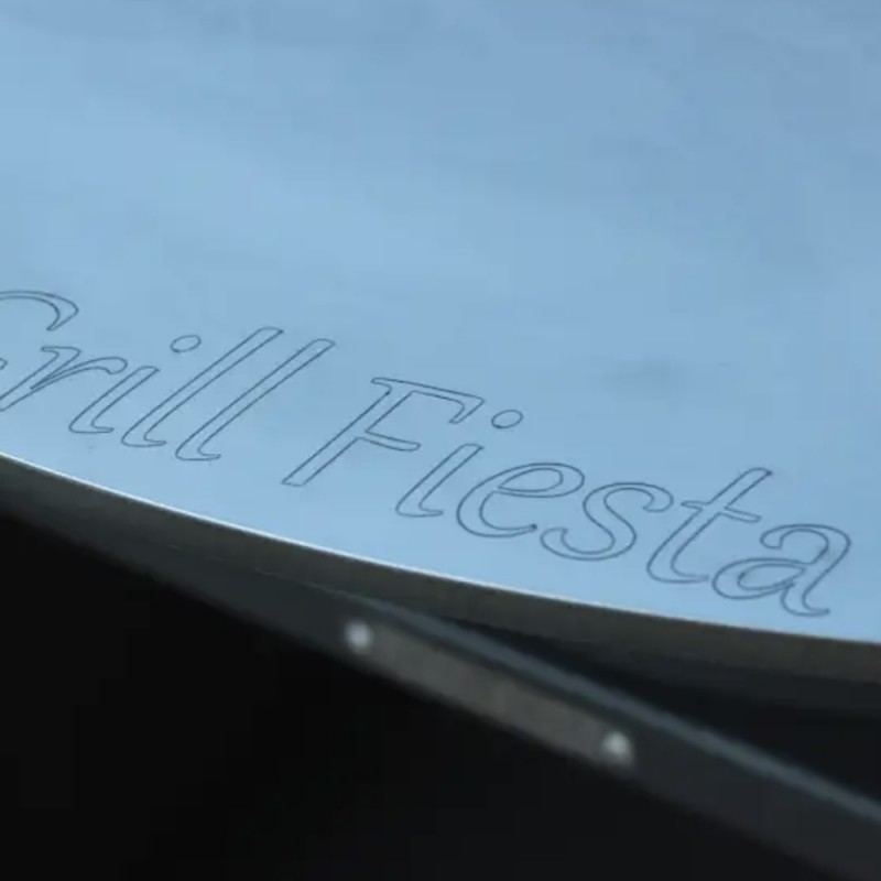 Détail de la plancha en acier avec logo Grill Fiesta gravé sur la surface de cuisson