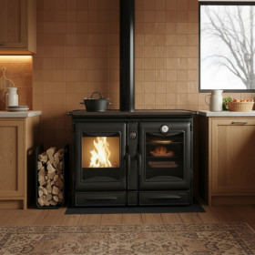 Cuisinière bois Alaska 12 kW noire avec four et foyer allumé, installée dans cuisine moderne