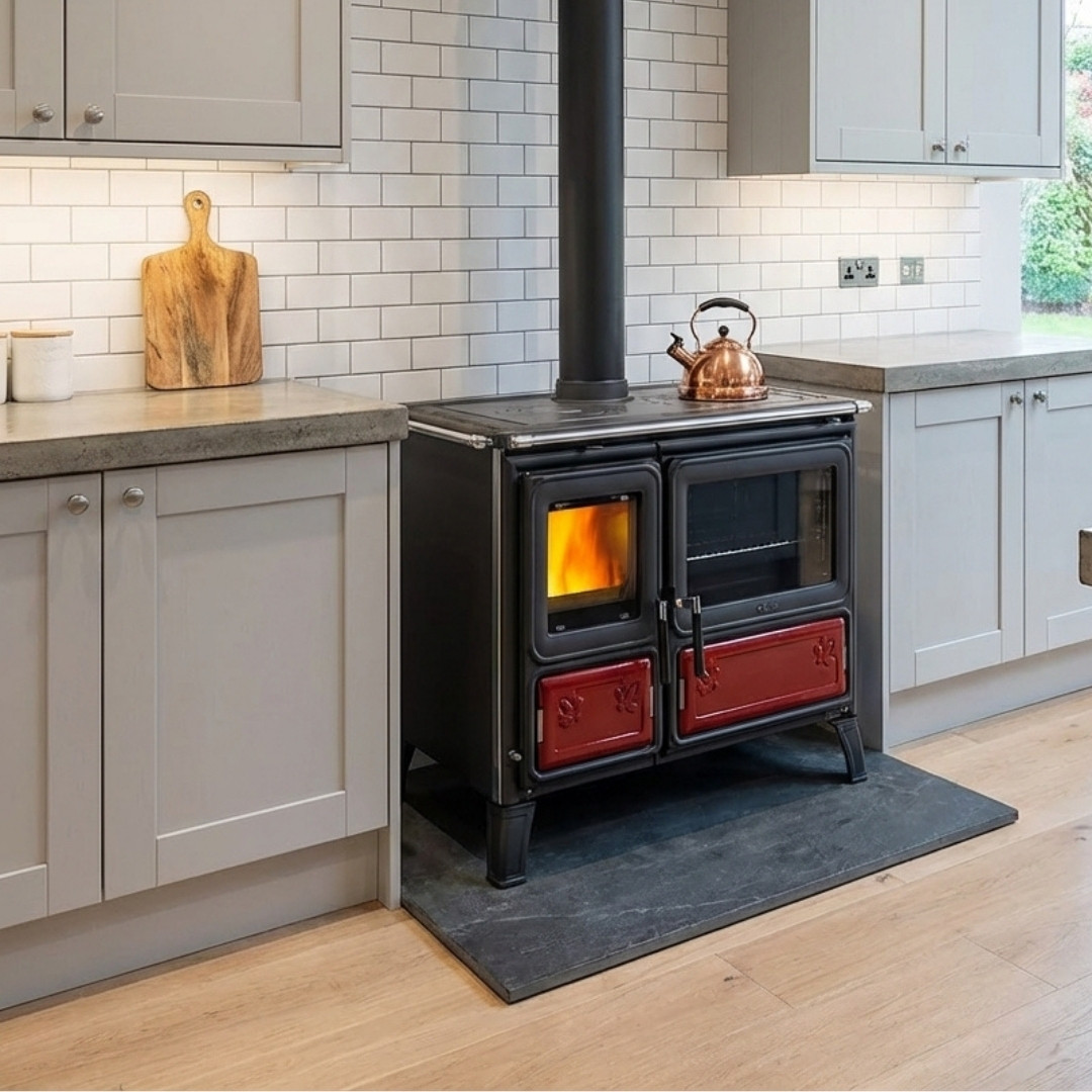 Cuisinière à bois Milly noire et rouge avec four, installée dans une cuisine moderne avec feu allumé