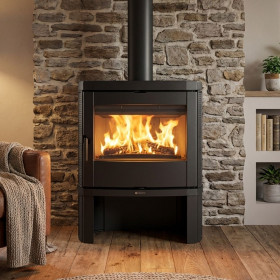 Poêle à bois Nordica Jennifer 2.0 noir en acier avec foyer allumé et vitre panoramique dans salon moderne