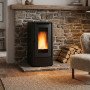Poêle à granulés Extraflame Teorema Plus noir 12 kW installé dans un salon avec mur en pierre
