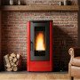 Poêle à granulés Dahiana rouge et noir 10 kW en situation devant mur en briques avec flammes allumées