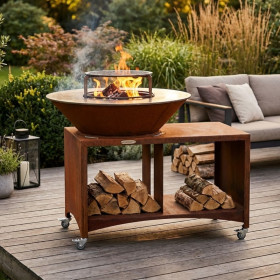 Brasero BBQ plancha Brasinox Fiesta Island Ø75 cm installé sur une terrasse avec rangement à bûcheso