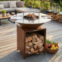Brasero plancha bois Brasinox Fiesta Ø75 cm installé sur une terrasse avec rangement à bûches
