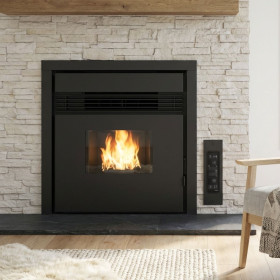 Insert à pellets Prezzemolo 7,5 kW encastré dans une cheminée en pierre