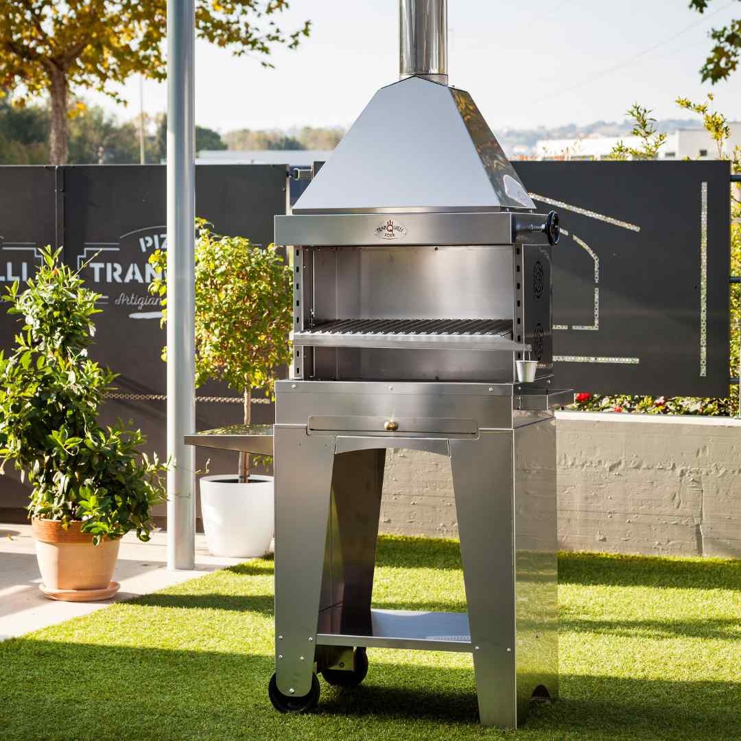 Barbecue au charbon en inox Foxy installé en extérieur sur terrasse