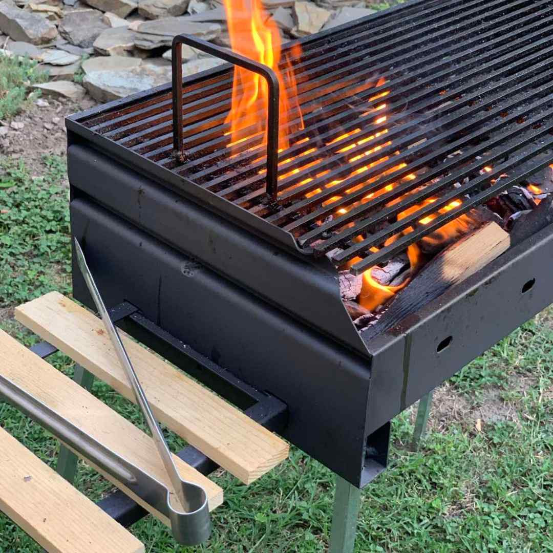 Flammes sous la grille du barbecue au charbon de bois portable Grill M