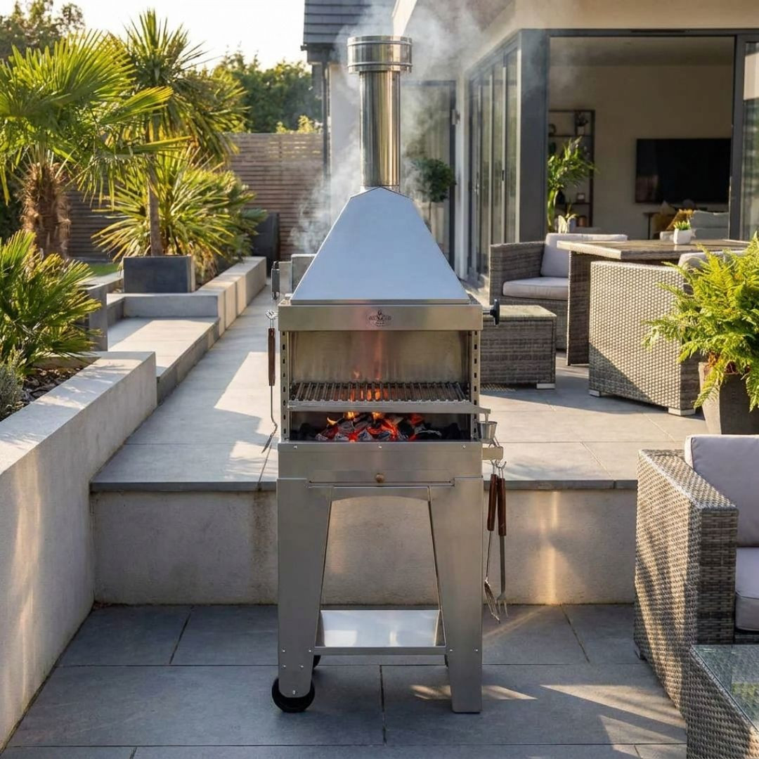 Barbecue au charbon Foxy en inox installé sur une terrasse extérieure près d’une cuisine de jardin