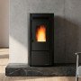 Poêle à granulés KETTY 5.0 noir 6,5 kW installé devant mur en béton