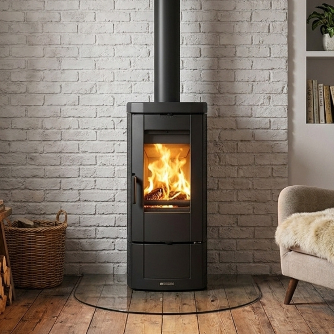 Poêle à bois en fonte émaillée Candy Lean 6,6 kW noir installé devant un mur en briques